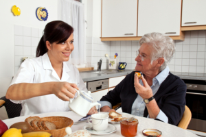 Caregiver pouring a cup of milk for the senior